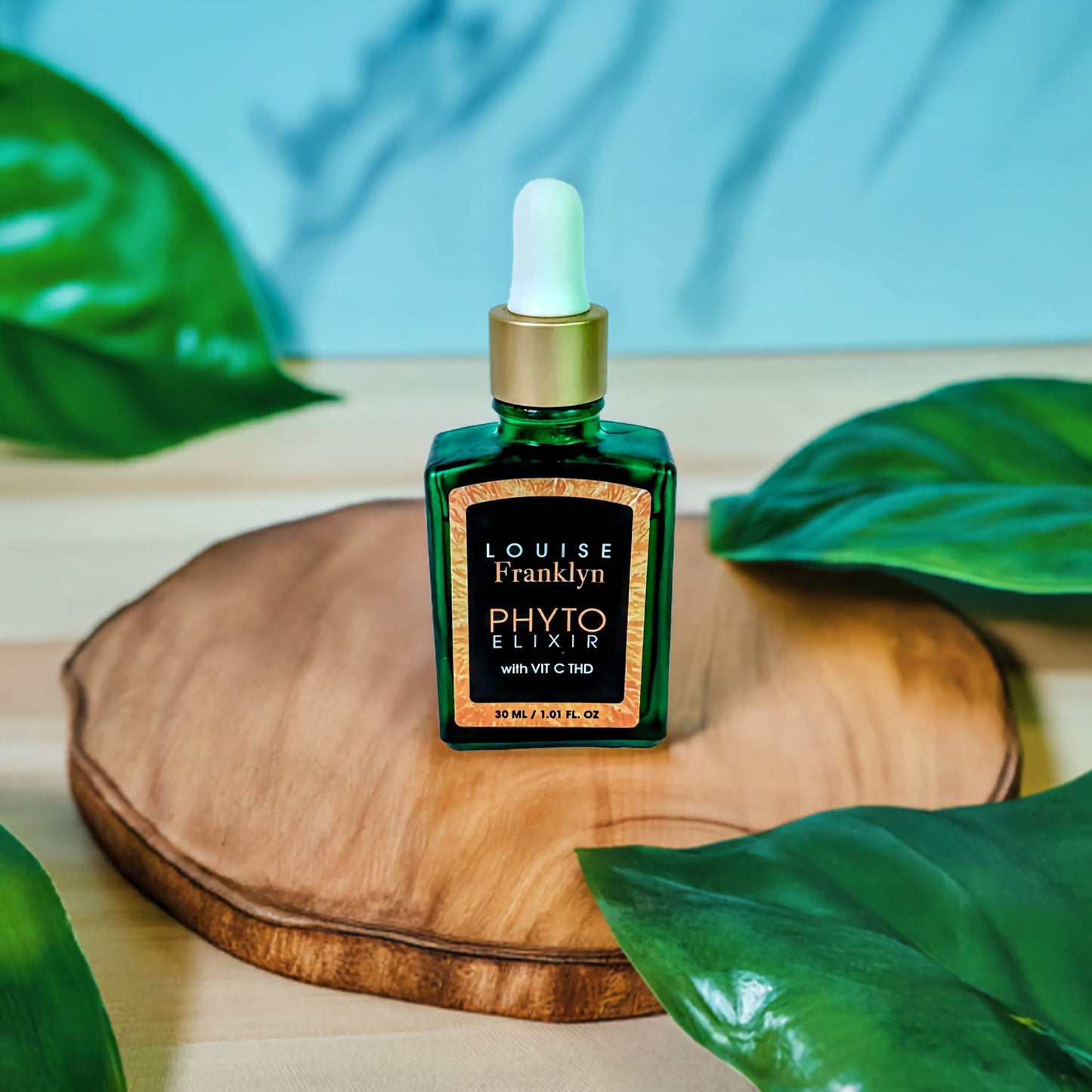 Green glass bottle of Louise Franklyn Phyto Elixir with Vitamin C THD, 30ml/1.01 oz oil. The bottle has an orange label with black and a gold lid. Silver Text and orange.